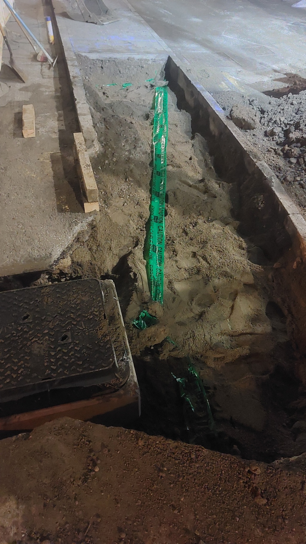Night-time utility trench with green ducting installed