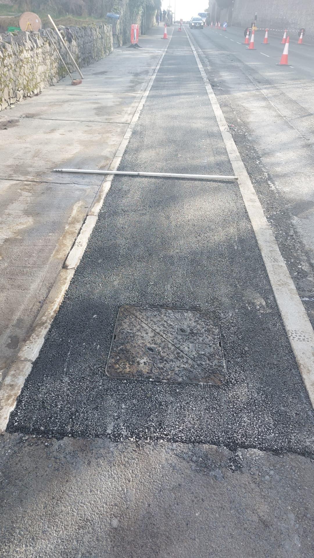 Newly reinstated asphalt footpath and manhole cover